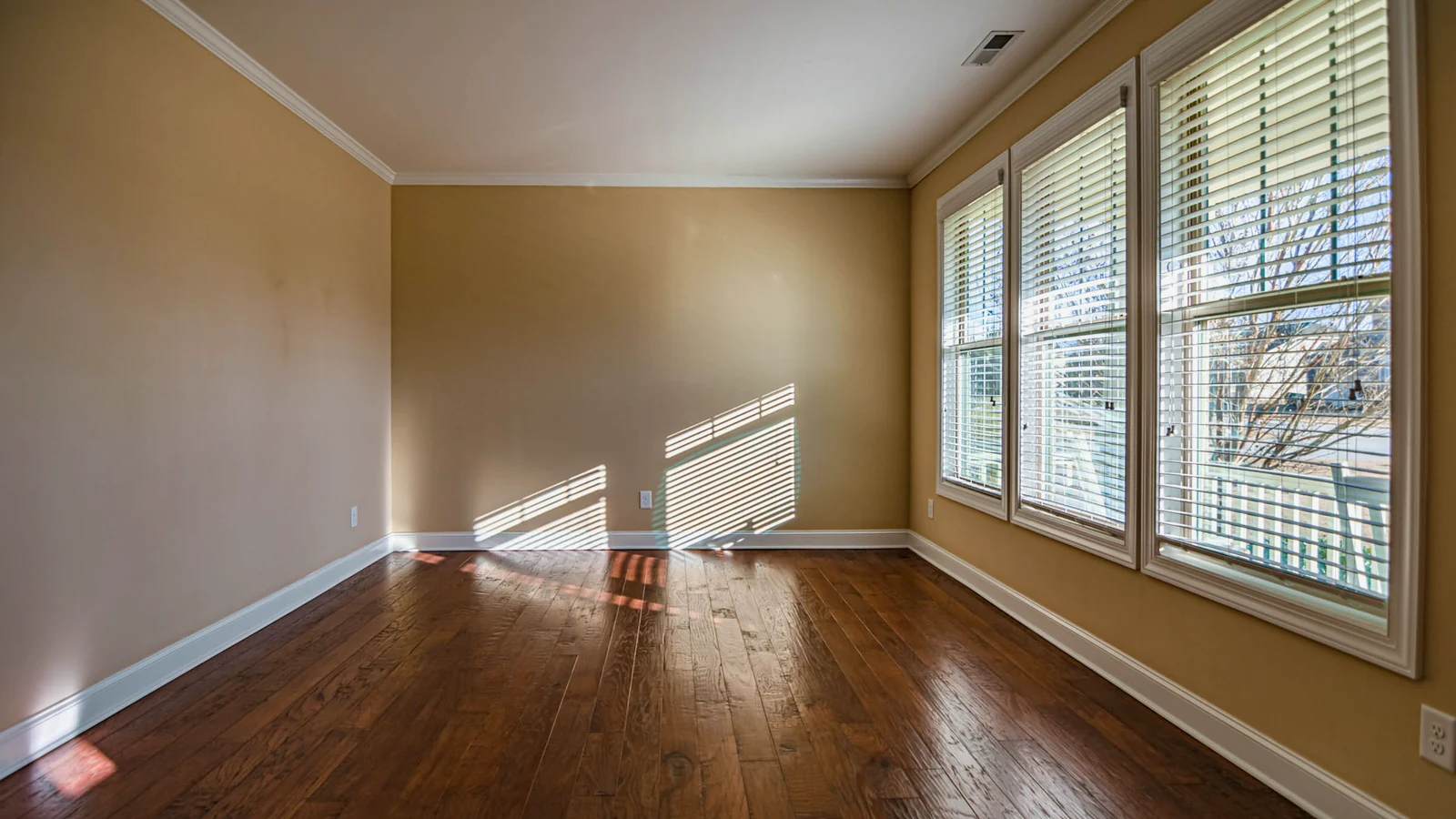 Suelo de tarima de madera barnizado junto a una ventana